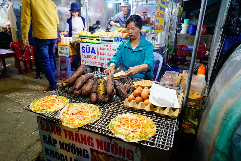 Grilled rice-paper snacks being prepared at a Da Lat market stall.